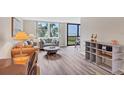 Comfortable living room with hardwood floors, neutral decor, and large windows offering partial beach views at 8710 Midnight Pass Rd # 202, Sarasota, FL 34242