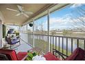 Relaxing screened porch overlooking a serene lake view, complete with comfortable seating and a ceiling fan at 6314 Bay Cedar Ln # 201, Bradenton, FL 34203
