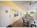 Inviting exterior patio with wooden flooring, ceiling fans, and comfortable seating area at 1020 Sun N Sea Dr # 104B, Sarasota, FL 34242