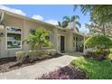 Inviting entrance of this lovely home showing manicured landscaping and walkway at 1046 Greystone Ln, Sarasota, FL 34232