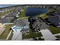 Aerial view of a blue two-story home with a spacious driveway near a pond at 11702 Tetrafin Dr, Riverview, FL 33579