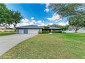 Charming single-story home features a well-manicured lawn, mature landscaping, and a three-car garage at 13615 4Th Ne Ave, Bradenton, FL 34212