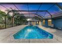 Stunning pool and spa area at dusk, with a screened enclosure and patio space at 13615 4Th Ne Ave, Bradenton, FL 34212