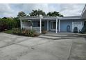Inviting covered front porch featuring lovely landscaping and seating at 1654 Blakemore Ln, Sarasota, FL 34231