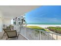 Relaxing balcony with seating overlooking the ocean, beach and beautifully landscaped grounds at 2301 Gulf Of Mexico Dr # 26N, Longboat Key, FL 34228
