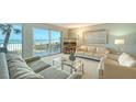 Inviting living room with comfortable seating and sliding glass doors leading to a beach view balcony at 2301 Gulf Of Mexico Dr # 26N, Longboat Key, FL 34228