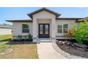 Inviting home entrance features a decorative glass double door, fresh landscaping, and a concrete walkway at 2366 Ann Arbor Rd, North Port, FL 34286