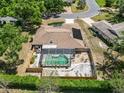 Aerial view of a home with a screened-in pool, fenced yard, and mature trees at 3600 Aster Dr, Sarasota, FL 34233