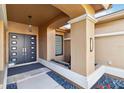 Inviting entryway with modern double doors, neutral stucco columns, and decorative rock garden accents creating a stylish entrance at 3941 Spyglass Hill Rd, Sarasota, FL 34238