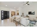 Bright living room with white furnishings, tile floors, recessed lighting, and a modern ceiling fan, creating an airy ambiance at 3941 Spyglass Hill Rd, Sarasota, FL 34238