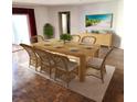 Staged dining room with a wooden table, wicker chairs, and a beach-themed painting on the wall at 435 S Gulfstream Ave # 605, Sarasota, FL 34236
