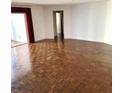 Open living room with parquet floors, a doorway, and red curtains framing the sliding door at 435 S Gulfstream Ave # 605, Sarasota, FL 34236