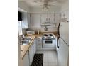 Efficient kitchen featuring white cabinets, classic appliances, and a functional layout at 4502 3Rd Street W Cir # 242, Bradenton, FL 34207