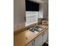 Functional kitchen with wooden countertops, white cabinets, stainless steel sink and modern appliances at 4502 3Rd Street W Cir # 242, Bradenton, FL 34207
