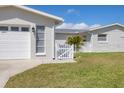 A bright exterior showcases a garage and a small picket fence, enhancing the curb appeal of this well-maintained home at 4911 Commonwealth Rd, Palmetto, FL 34221