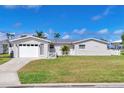 Inviting single-story home with well-manicured lawn, featuring a garage, fresh paint, and charming white picket fence at 4911 Commonwealth Rd, Palmetto, FL 34221
