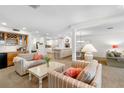 Open concept living room with ample seating, a bar, and a view into the bright kitchen and dining area at 5055 Gulf Of Mexico Dr # 435, Longboat Key, FL 34228