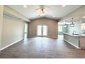 Open-concept living room with vaulted ceilings, wood-look tile flooring, and an adjacent kitchen at 5113 Rilke Ln, Port Charlotte, FL 33981
