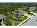 Aerial view of a landscaped home with a screened-in lanai and well-maintained lawns in a lush, green community at 5603 90Th Avenue E Cir, Parrish, FL 34219