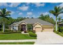 Charming single-story home featuring mature landscaping, a stone accent wall, and a convenient two-car garage at 5603 90Th Avenue E Cir, Parrish, FL 34219