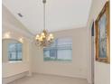 Bright dining room with tray ceilings, decorative chandelier, tile floors and large windows for a modern look at 6442 Tailfeather Way, Bradenton, FL 34203