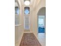 Bright foyer with arched doorway, tile floors, and decorative rug adds elegance to this inviting home at 6442 Tailfeather Way, Bradenton, FL 34203