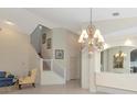 Elegant living area with staircase, chandelier, large mirror, and neutral tones creates a spacious atmosphere at 6442 Tailfeather Way, Bradenton, FL 34203
