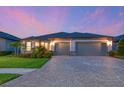 Charming home with a paver driveway, two-car garage, and manicured lawn at 8722 Backshore Ln, Parrish, FL 34219