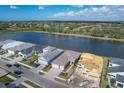 Aerial view of neighborhood showcasing lake, landscaping, and multiple single-Gathering homes on a sunny day at 10217 Canaveral Cir, Sarasota, FL 34241