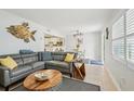 Cozy living area with a comfortable gray sectional, unique coffee table, and an open view to the kitchen at 117 7Th N St # 5, Bradenton Beach, FL 34217
