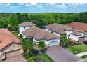 A high-angle view showcasing the home's layout, including the tile roof and brick driveway at 13902 Messina Loop, Bradenton, FL 34211