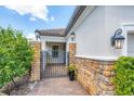 Charming front porch with stone pillars, sconce lighting, brick pavers, and a lovely gated entry at 13902 Messina Loop, Bradenton, FL 34211