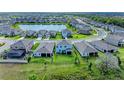 Aerial view of a home with a backyard, showcasing the surrounding community and a picturesque lake at 17669 Cantarina Cv, Bradenton, FL 34211