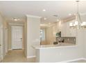 Bright kitchen with white cabinets, modern appliances, stylish backsplash, and a breakfast bar overlooking the entry at 23819 Collina Way # 102, Port Charlotte, FL 33980