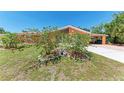 This lovely home has landscaping with flowering bushes and statue decor on a well-manicured lawn at 3053 Monica Pkwy, Sarasota, FL 34234