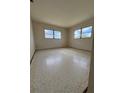 Simple bedroom with two windows offering natural light, and tile flooring throughout the room at 3123 Chase Cir, Sarasota, FL 34231