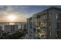 Beautiful view of the modern condo exterior showing multiple balconies and stunning sunset view at 325 Golden Gate Pt # 1004, Sarasota, FL 34236