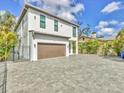 Wide driveway leading to a modern home with a prominent garage, set against a blue sky backdrop at 4112 Swift Rd, Sarasota, FL 34231