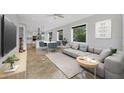 Open-concept living room featuring modern décor, tile floors, and ample natural light from several windows at 4112 Swift Rd, Sarasota, FL 34231