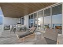 Spacious covered balcony featuring lounge chairs and outdoor dining with breathtaking ocean vistas at 4651 Gulf Of Mexico Dr # 304, Longboat Key, FL 34228