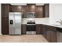 Modern kitchen with stainless steel appliances, dark wood cabinets, and stone countertops at 5543 Pleasantview Ct, Bradenton, FL 34211