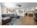Open-concept living room featuring a stylish gray sectional sofa and hardwood floors at 5704 2Nd Avenue Nw Dr, Bradenton, FL 34209