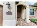 Inviting front porch with elegant pillars and stone accents, leading to a warm wooden door at 5810 Brandon Run, Bradenton, FL 34211