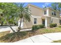 Beige two-story townhouse featuring a well-manicured lawn and tropical palm trees at 6418 Rosefinch Ct # 103, Lakewood Ranch, FL 34202