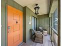 Inviting front porch with seating, nautical decor, and a vibrant orange entry door at 6500 Flotilla Dr # 126, Holmes Beach, FL 34217