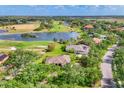 Aerial view of a single-story home and community with golf course, lakes, and lush landscaping at 7408 S Serenoa Dr, Sarasota, FL 34241