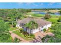 Aerial view of a single-story home, lush landscaping, and brick driveway situated on the golf course at 7408 S Serenoa Dr, Sarasota, FL 34241
