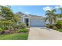 Lovely single-story home with a two car garage and landscaped yard showcasing a modern light blue exterior at 8110 Trimbelle Ter, Parrish, FL 34219