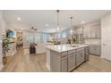 Modern kitchen featuring stainless steel appliances, stylish gray cabinets, quartz countertops and an island with pendant lighting at 8110 Trimbelle Ter, Parrish, FL 34219