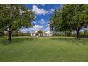Charming single-story home with a sprawling green lawn, mature trees, and inviting curb appeal at 8223 Snowy Egret Pl, Bradenton, FL 34202